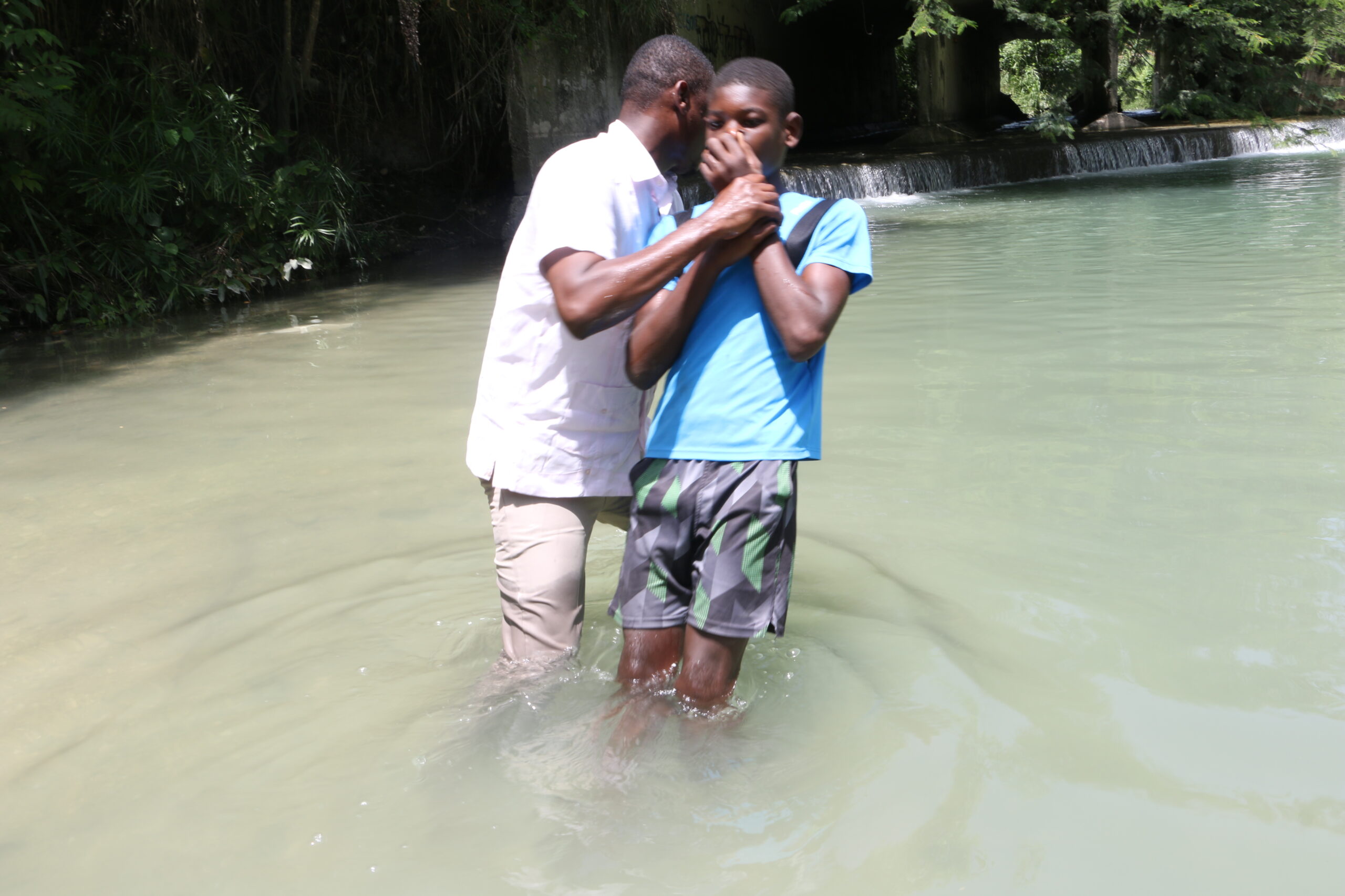 Haitian teen being baptized at Camp Hope